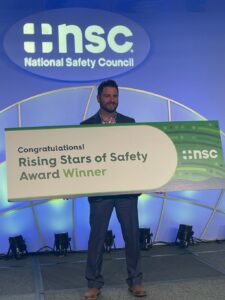 Chris Cameron PT, DPT holding sign at the Rising Star of Safety Award event